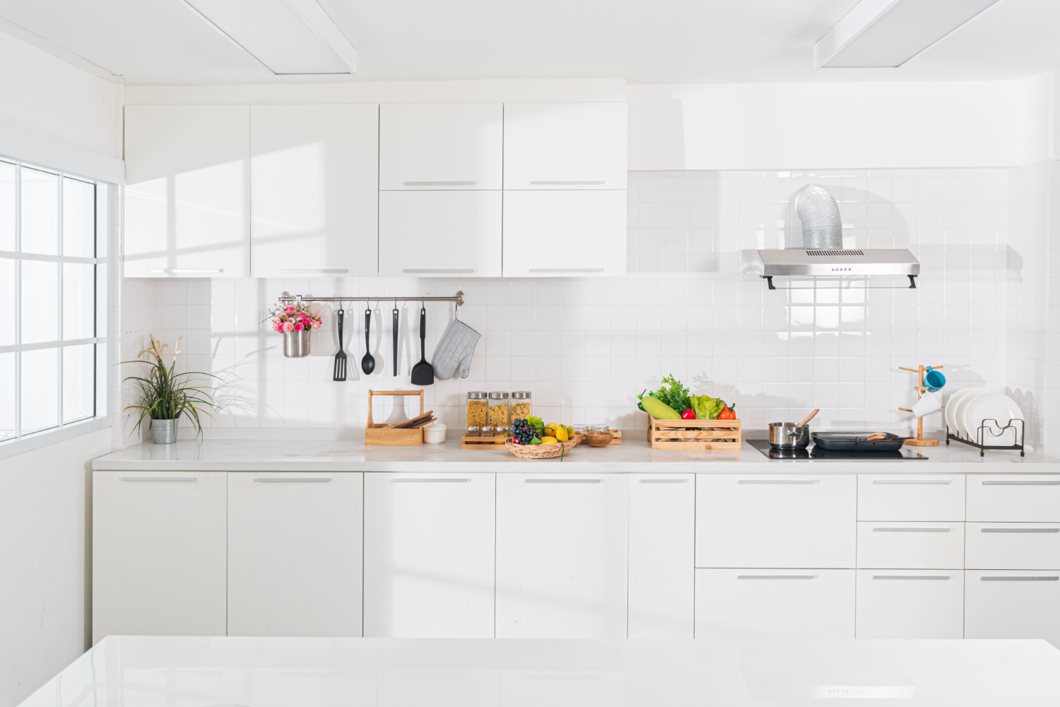Bright, spotless white kitchen with gleaming counters and cabinets